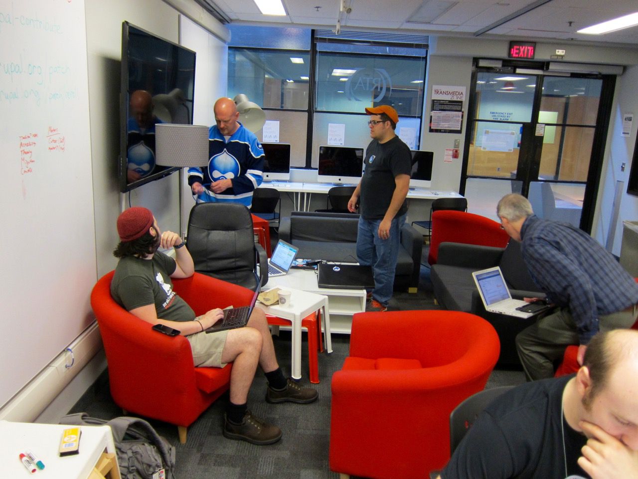 DrupalNorth 2015 sprinters gathering around and setting up a television, about to set up Drupal Console.